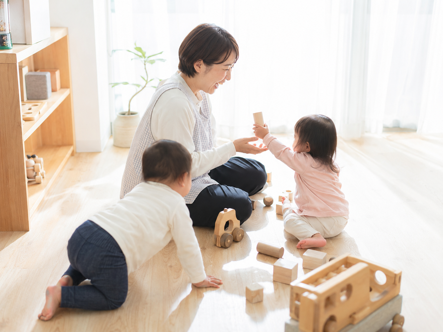 保育スタッフが子どもたちと積み木で遊ぶ様子